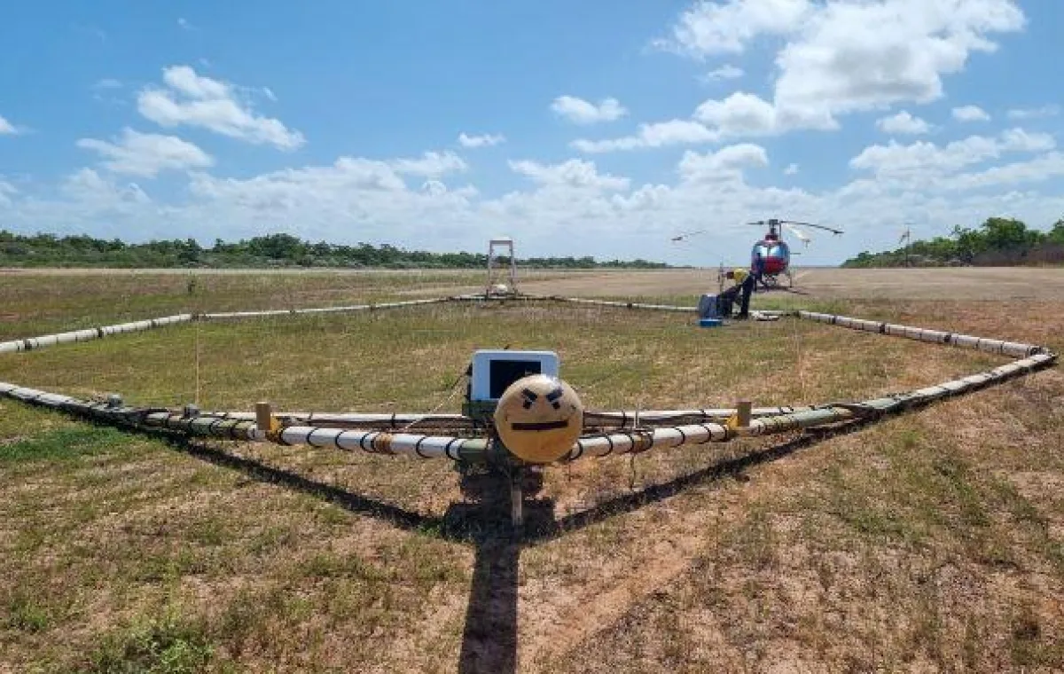 Aerial monitoring equipment and helicopter stationary in paddock