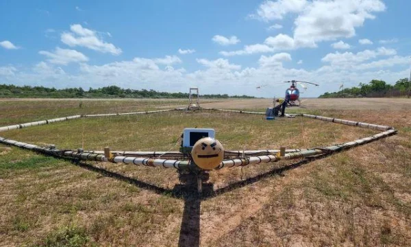 Aerial monitoring equipment and helicopter stationary in paddock