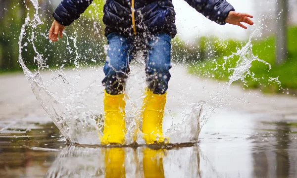 child jumping in puddle